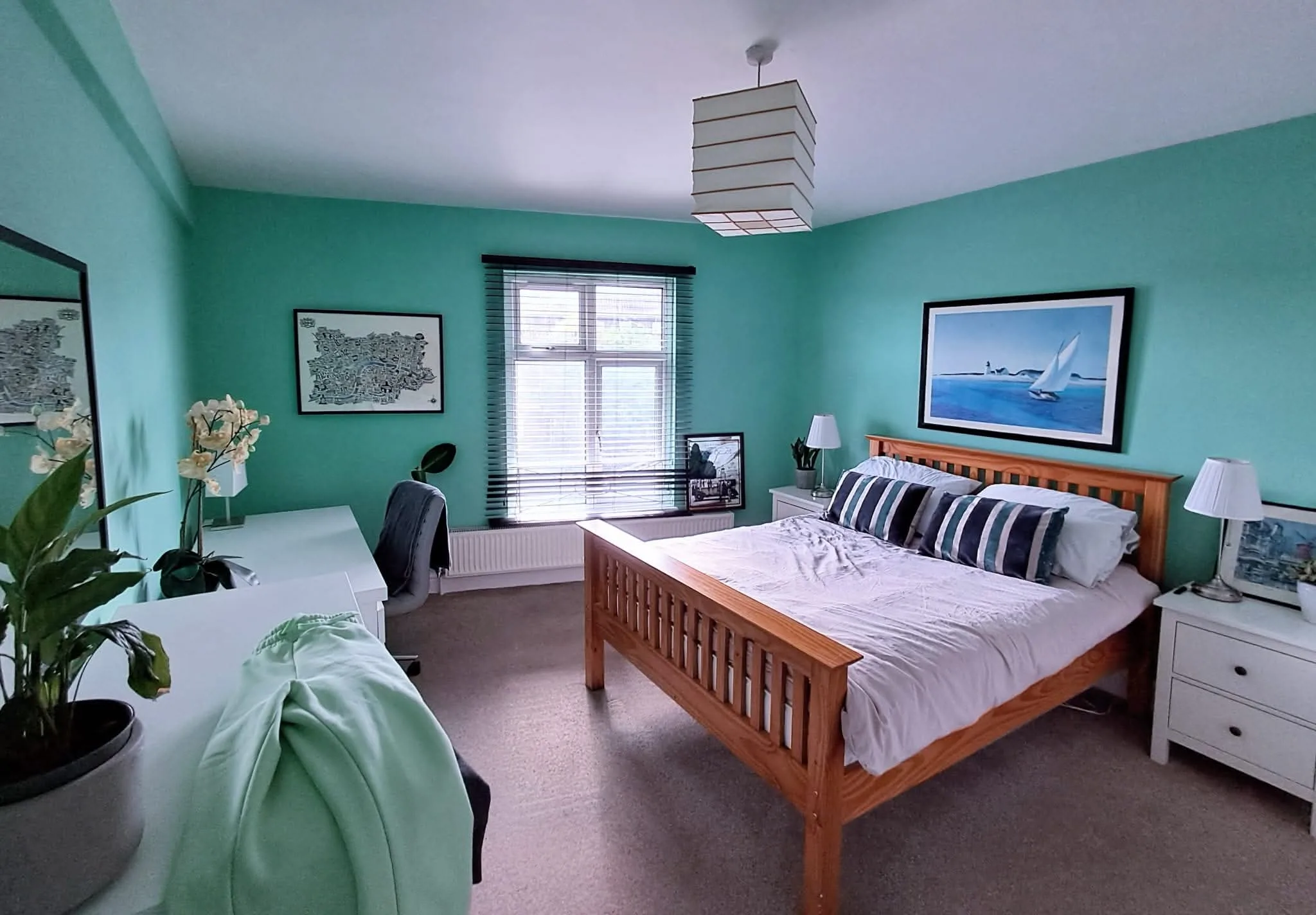 Modern bedroom with turquoise walls and wooden bed