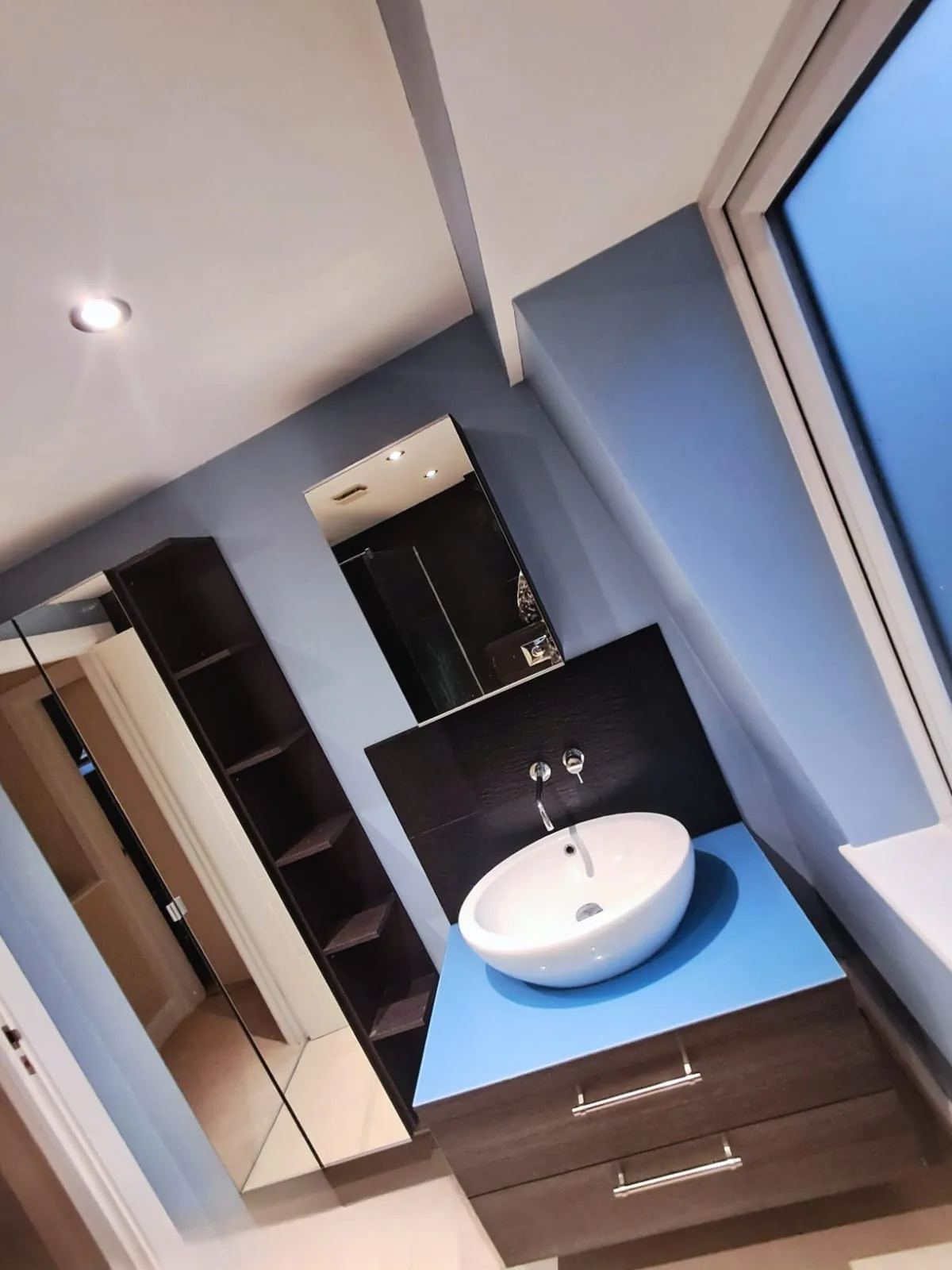 Modern bathroom with white vessel sink and blue countertop