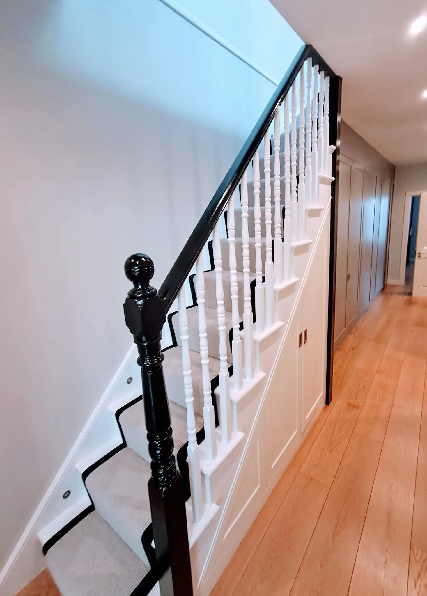 Modern staircase with white balusters and black railings