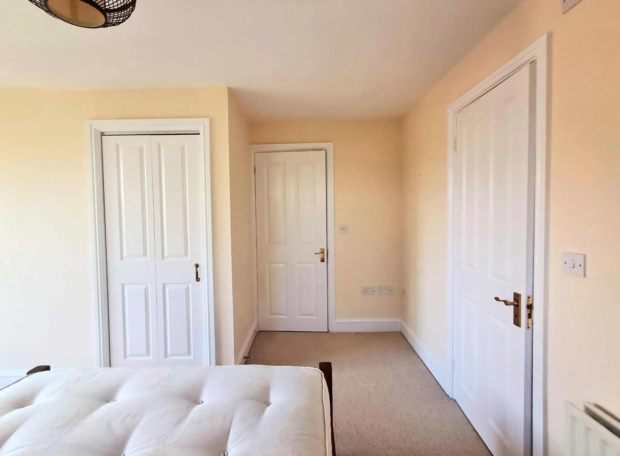 Modern bedroom interior with white doors and cream walls