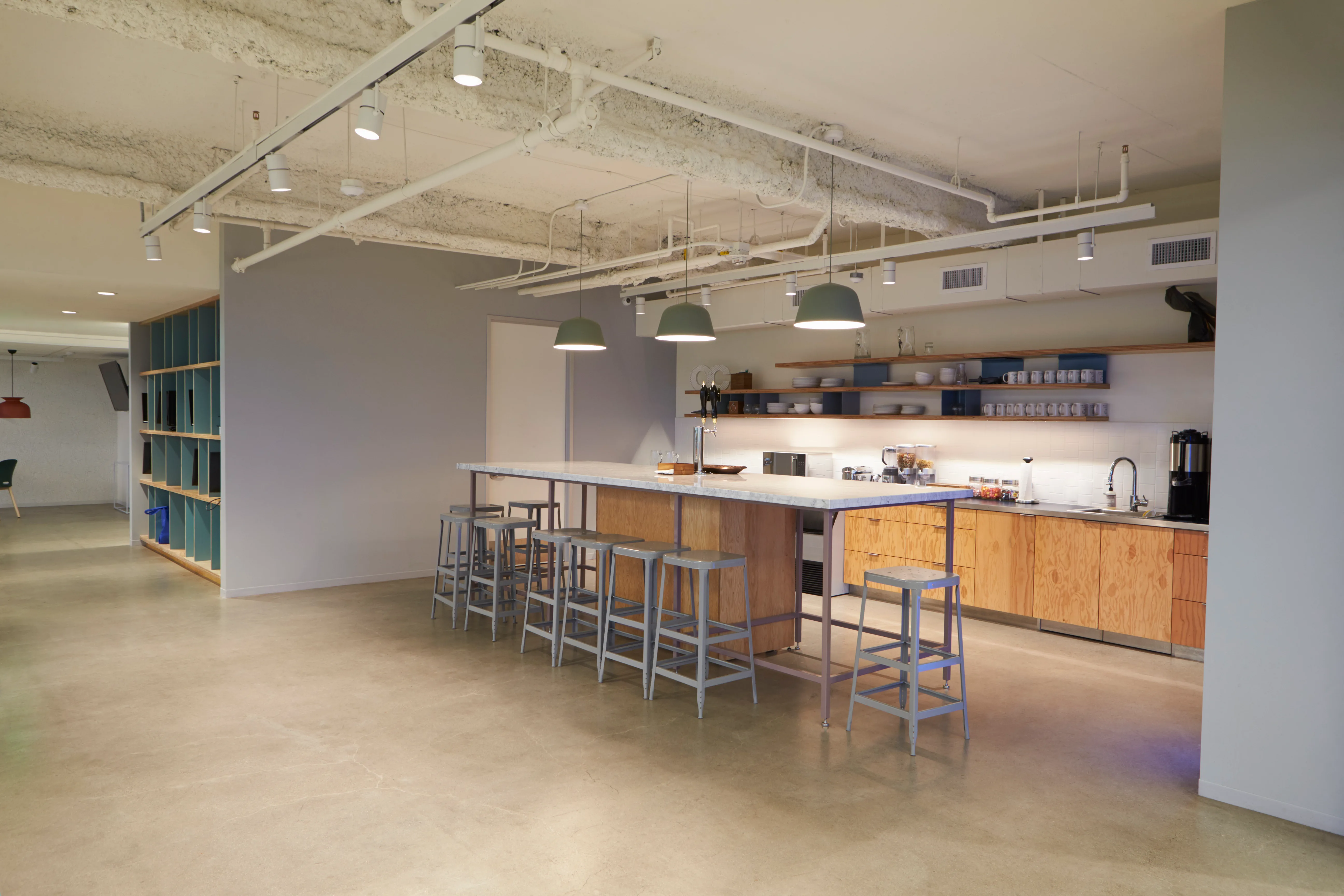 Modern kitchen interior featuring a long bar with stools and stylish lighting fixtures