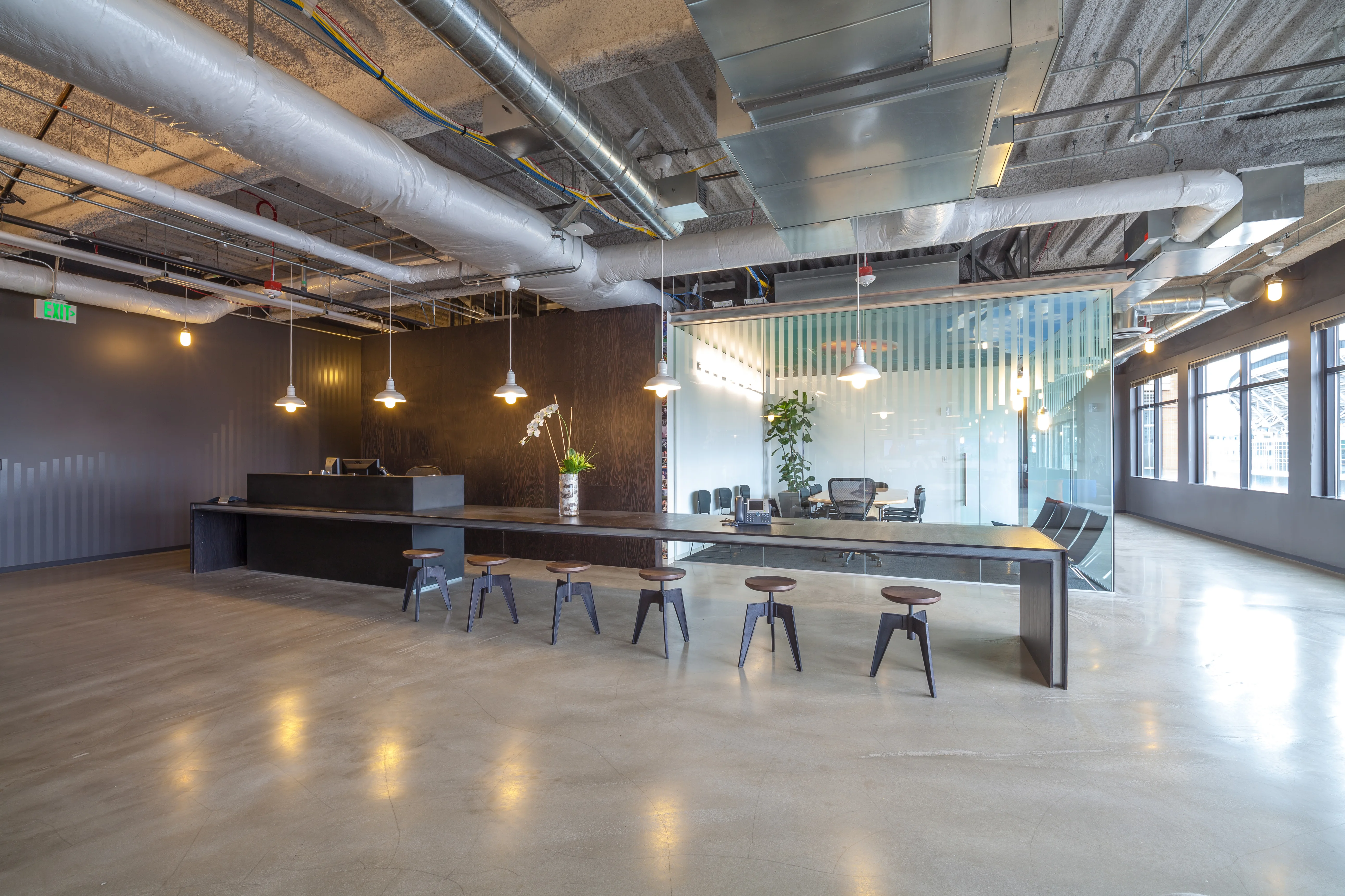 Modern commercial interior with a reception area, featuring sleek furniture and glass partitions