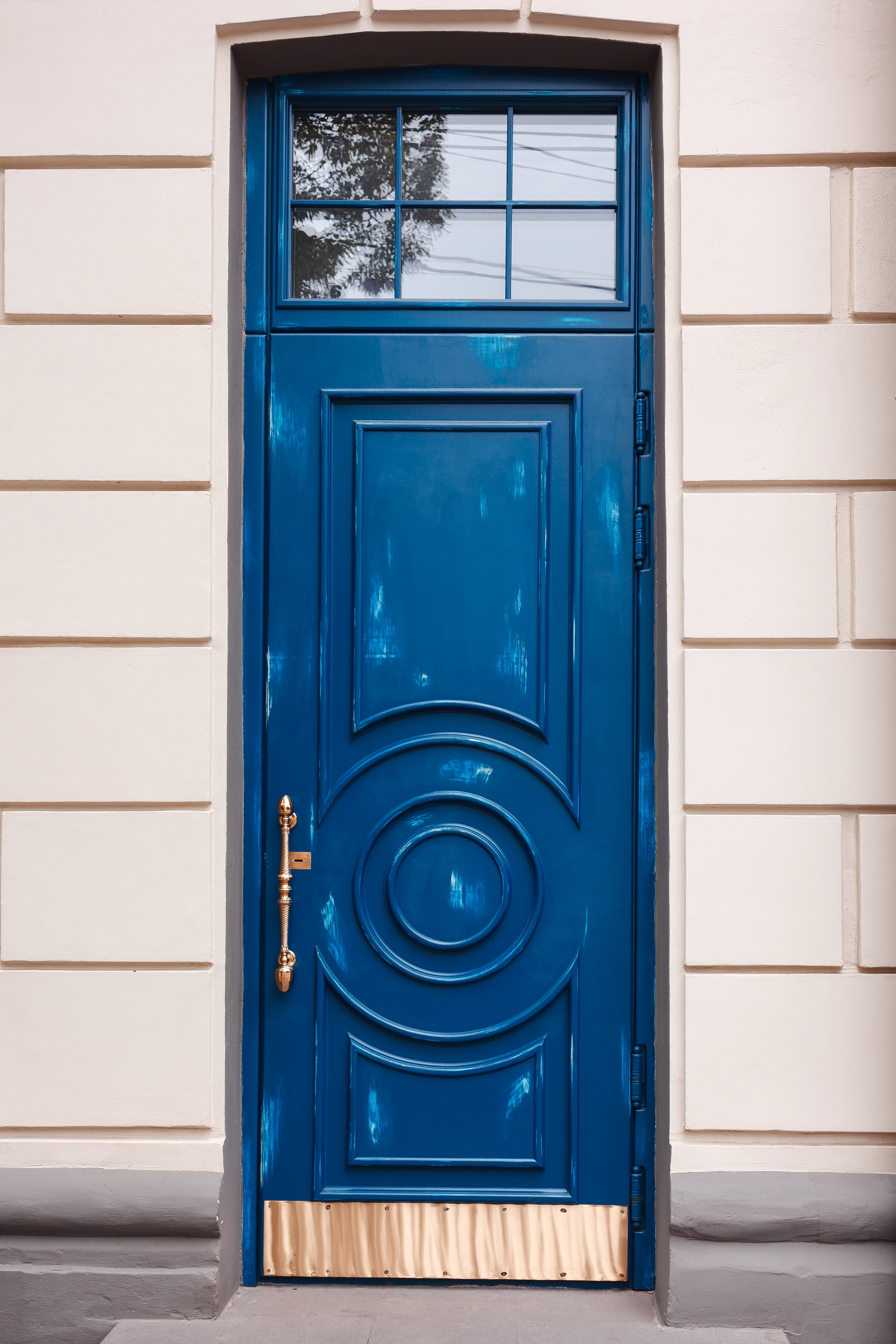 Close-up of a freshly painted blue exterior door with decorative details