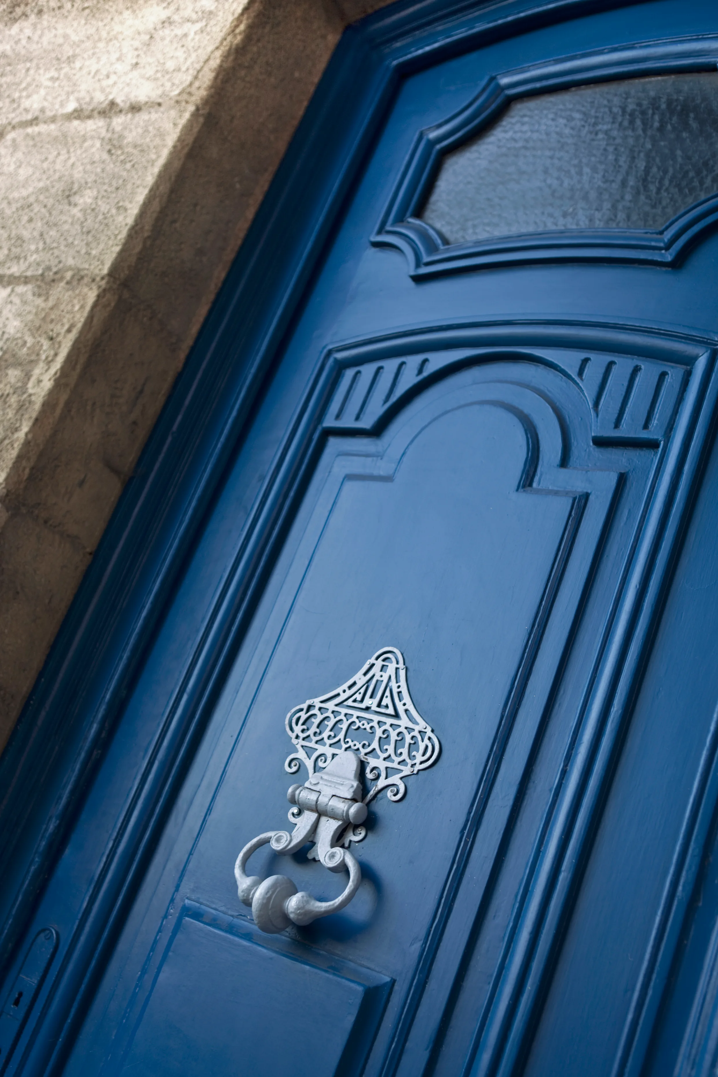 Close-up of a blue painted door with an ornate knocker