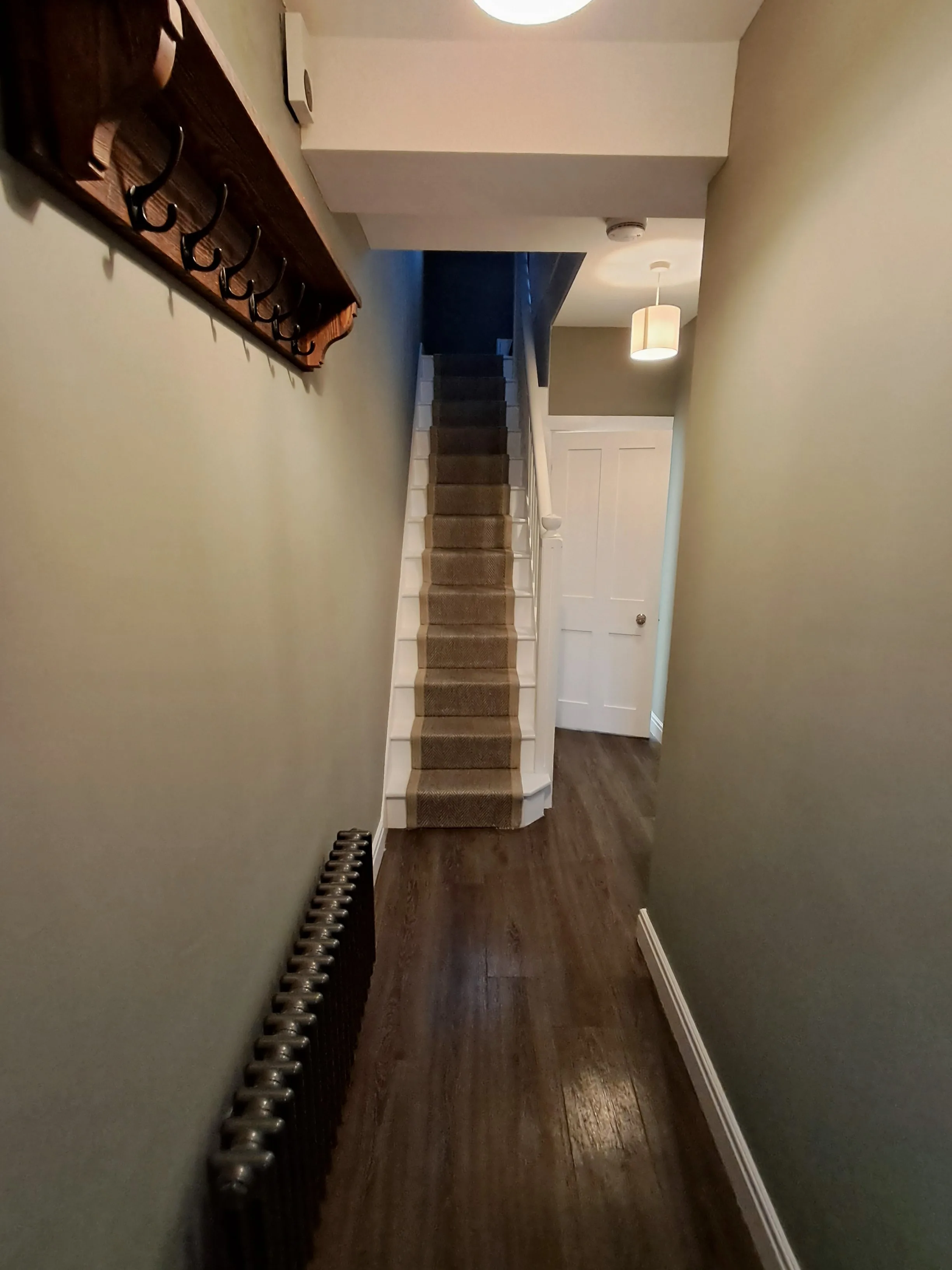 A well-painted hallway with a staircase leading up, showcasing interior wall painting
