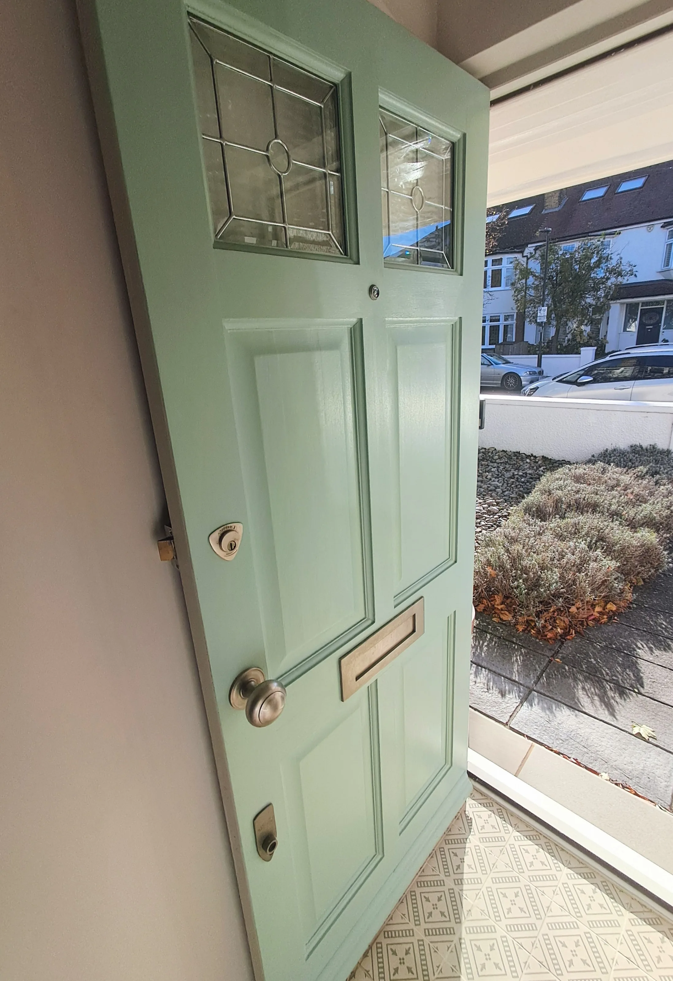Freshly painted mint green front door with decorative glass panels, showcasing attention to detail in exterior painting