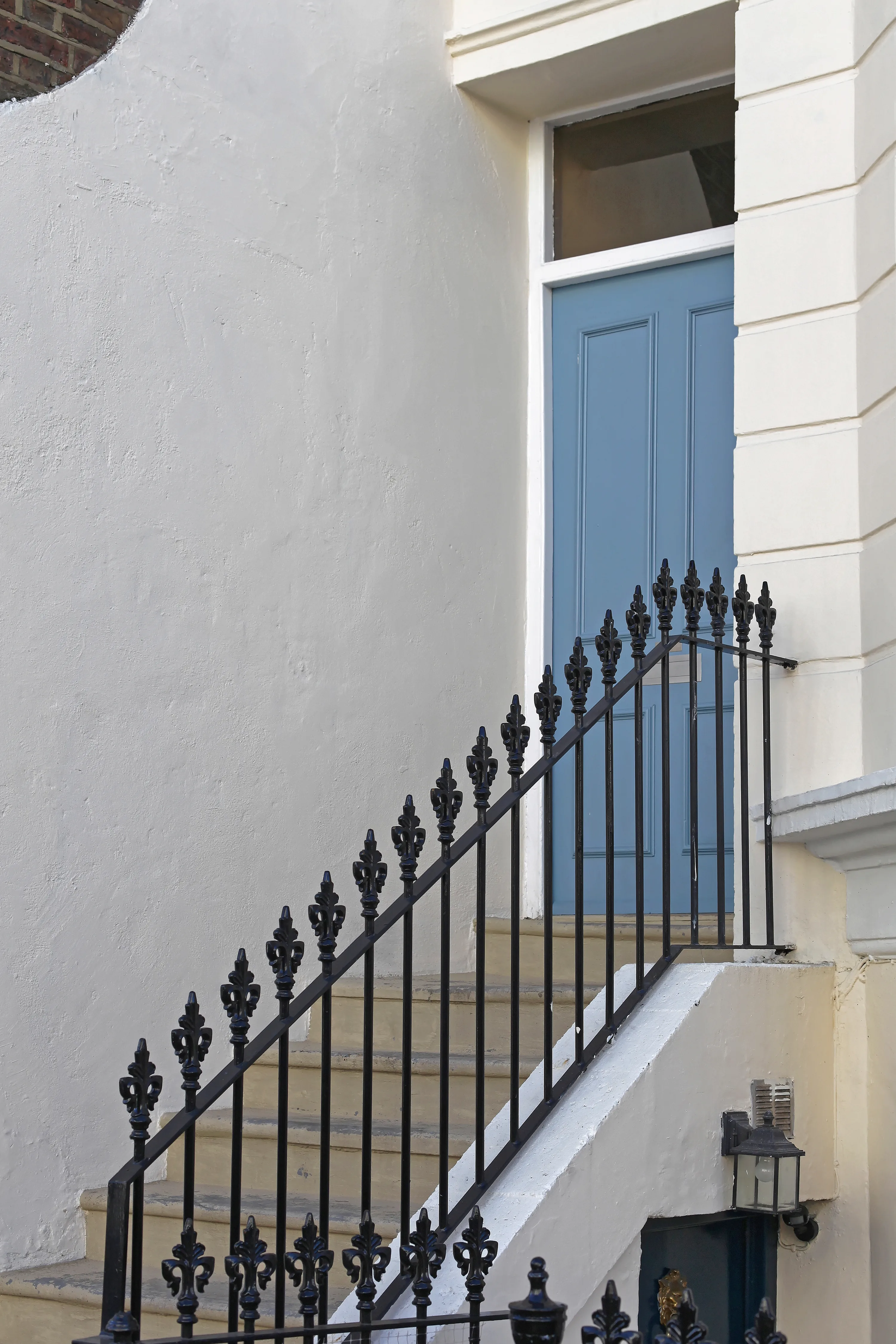 Blue door with elegant railing and white wall in a residential setting