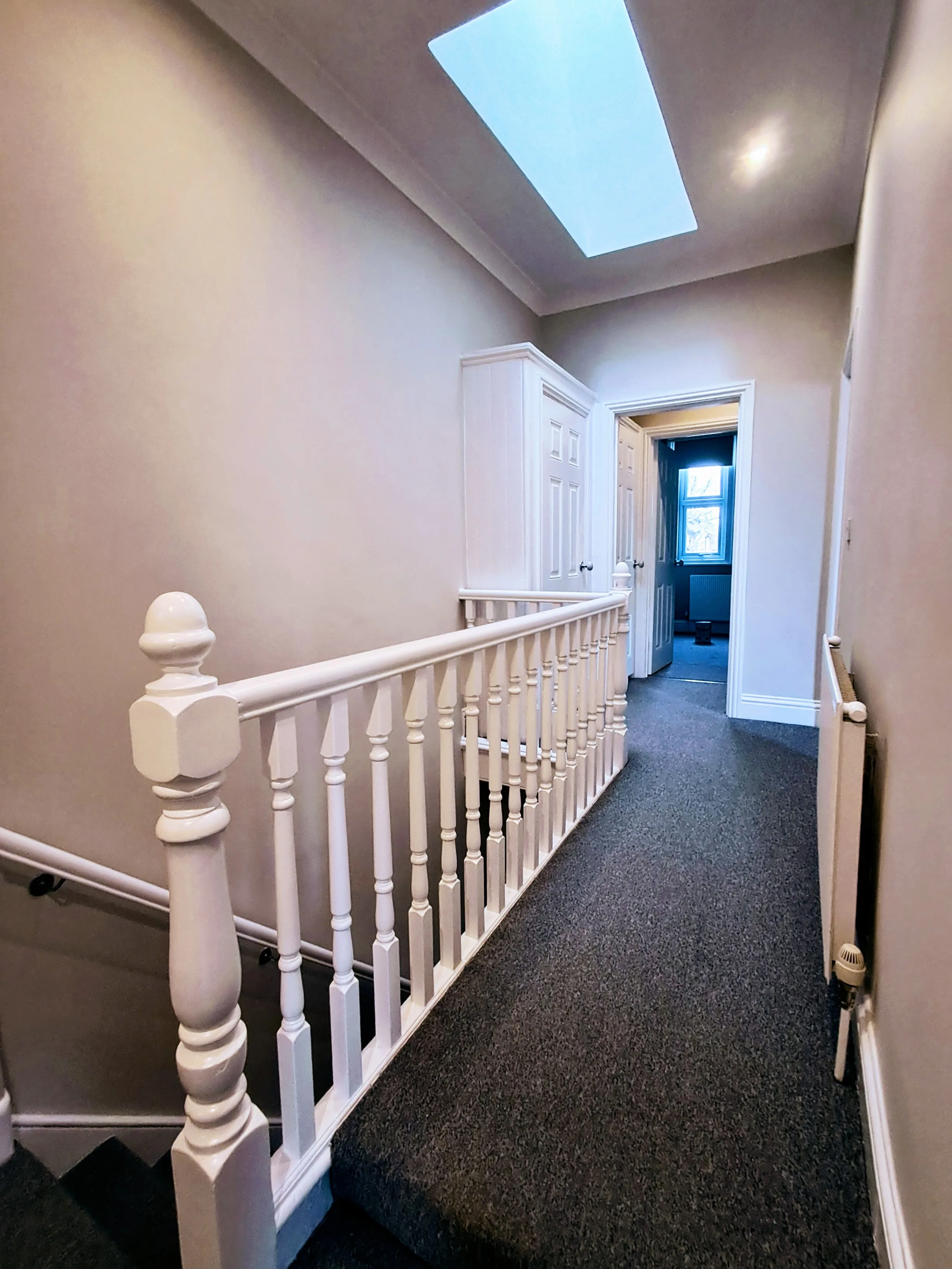 Well-painted interior staircase with white wooden railings and soft lighting