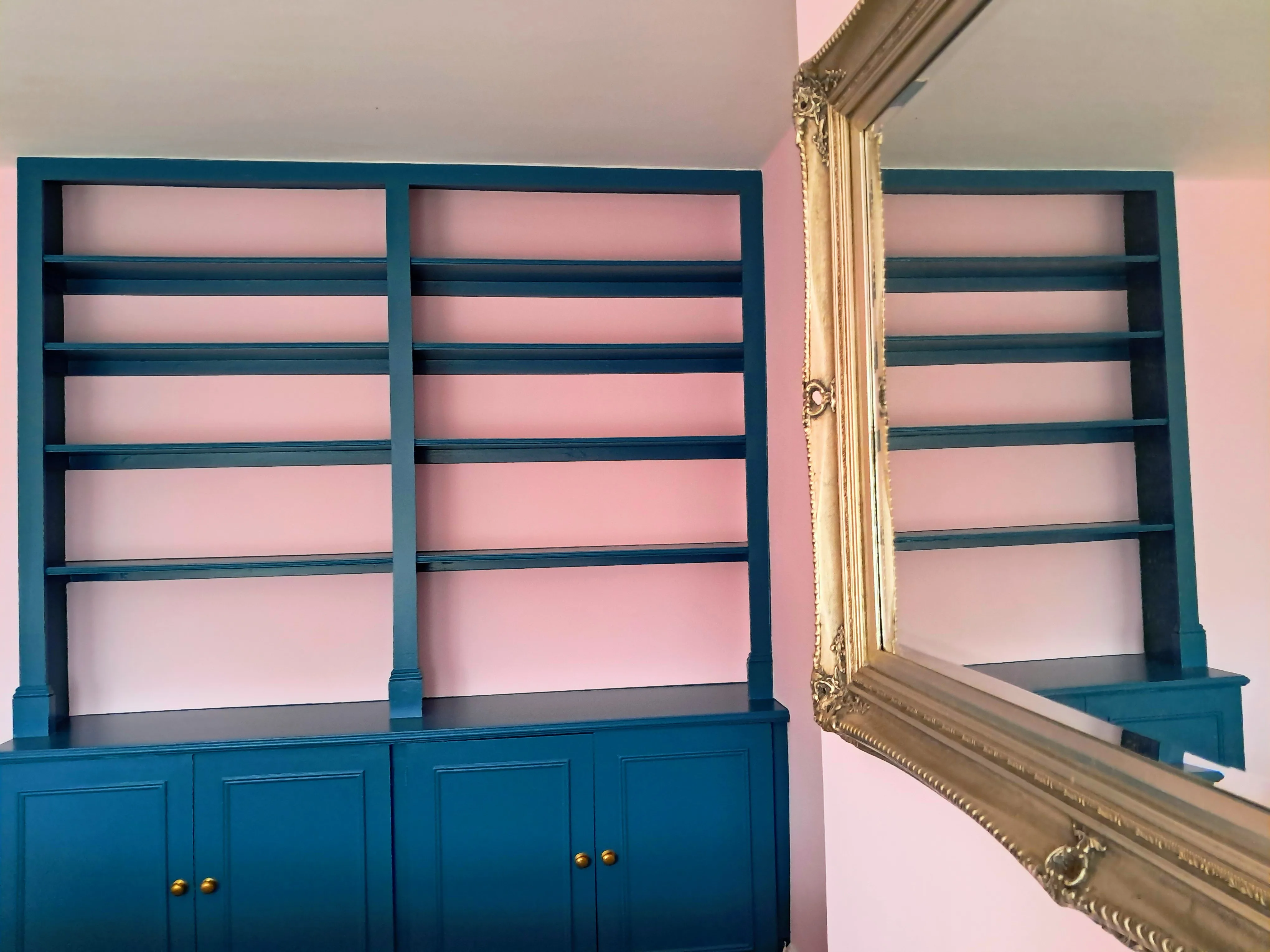 Interior painting of a blue shelving unit against a pink wall with a mirror reflection
