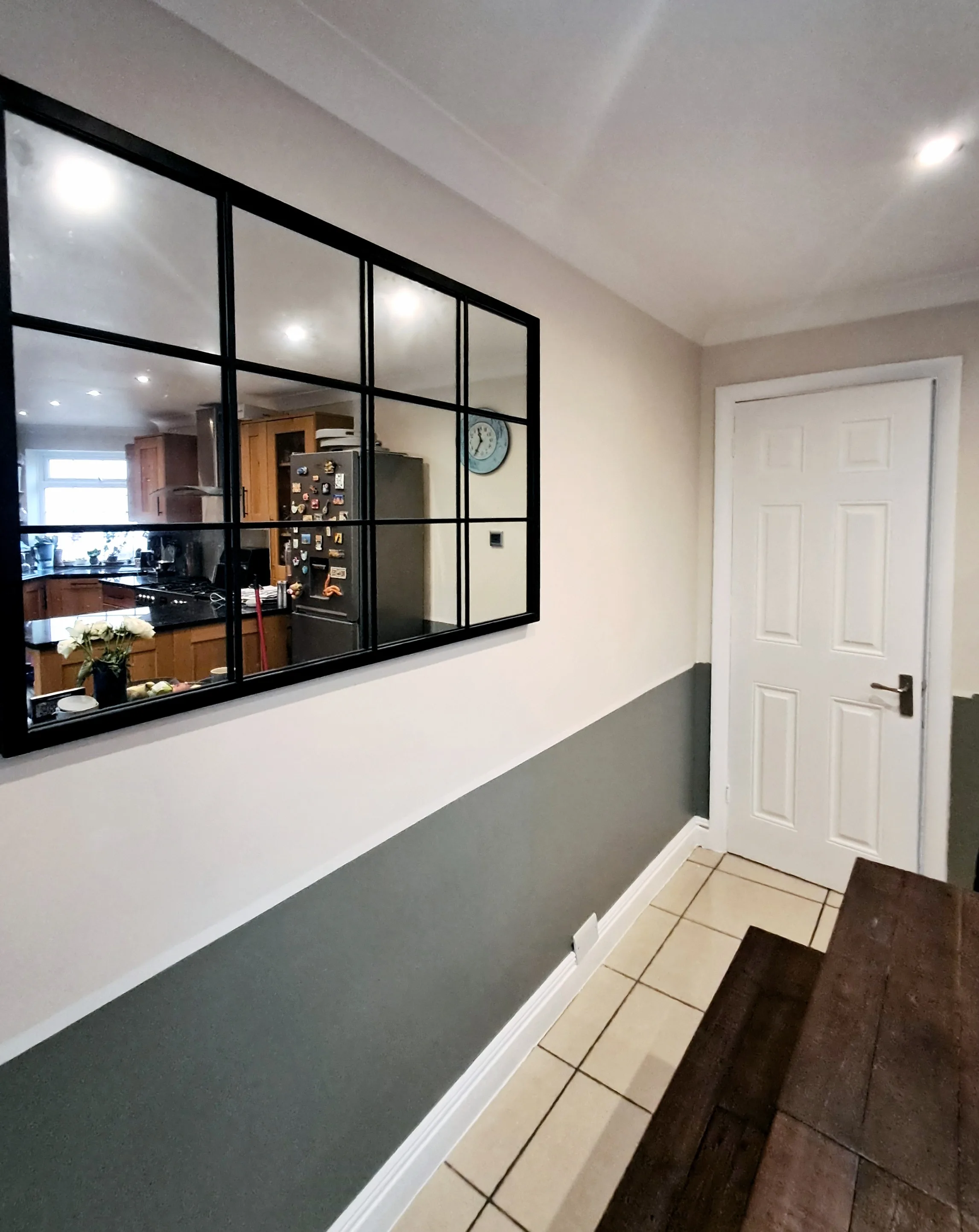 Interior wall painting with a two-tone color scheme and decorative mirror