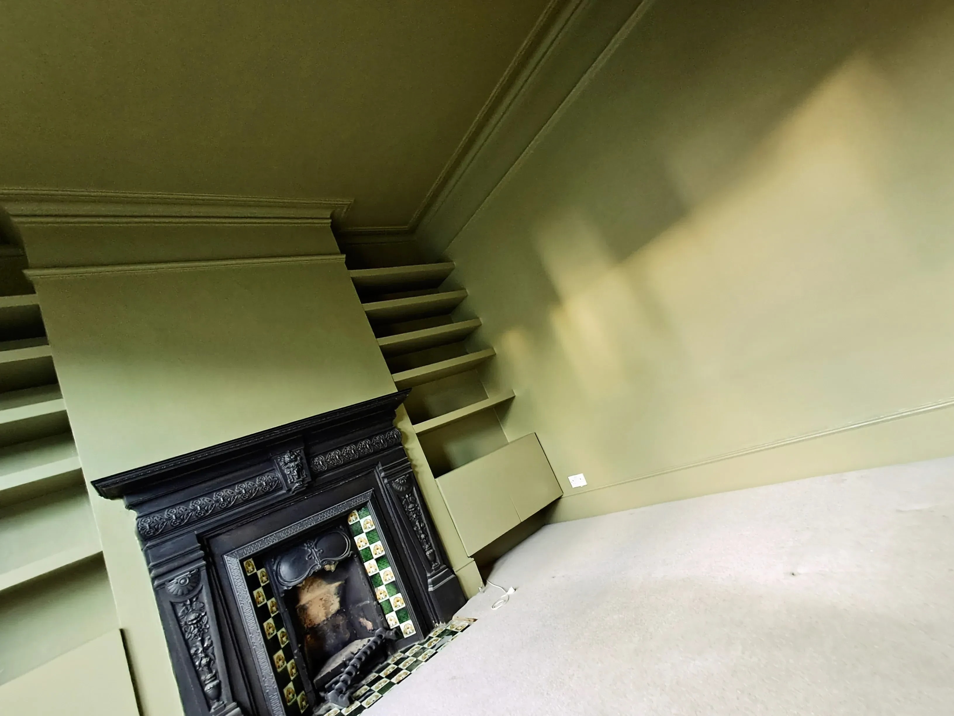 A beautifully painted interior with a fireplace, showcasing meticulous wall and ceiling finish