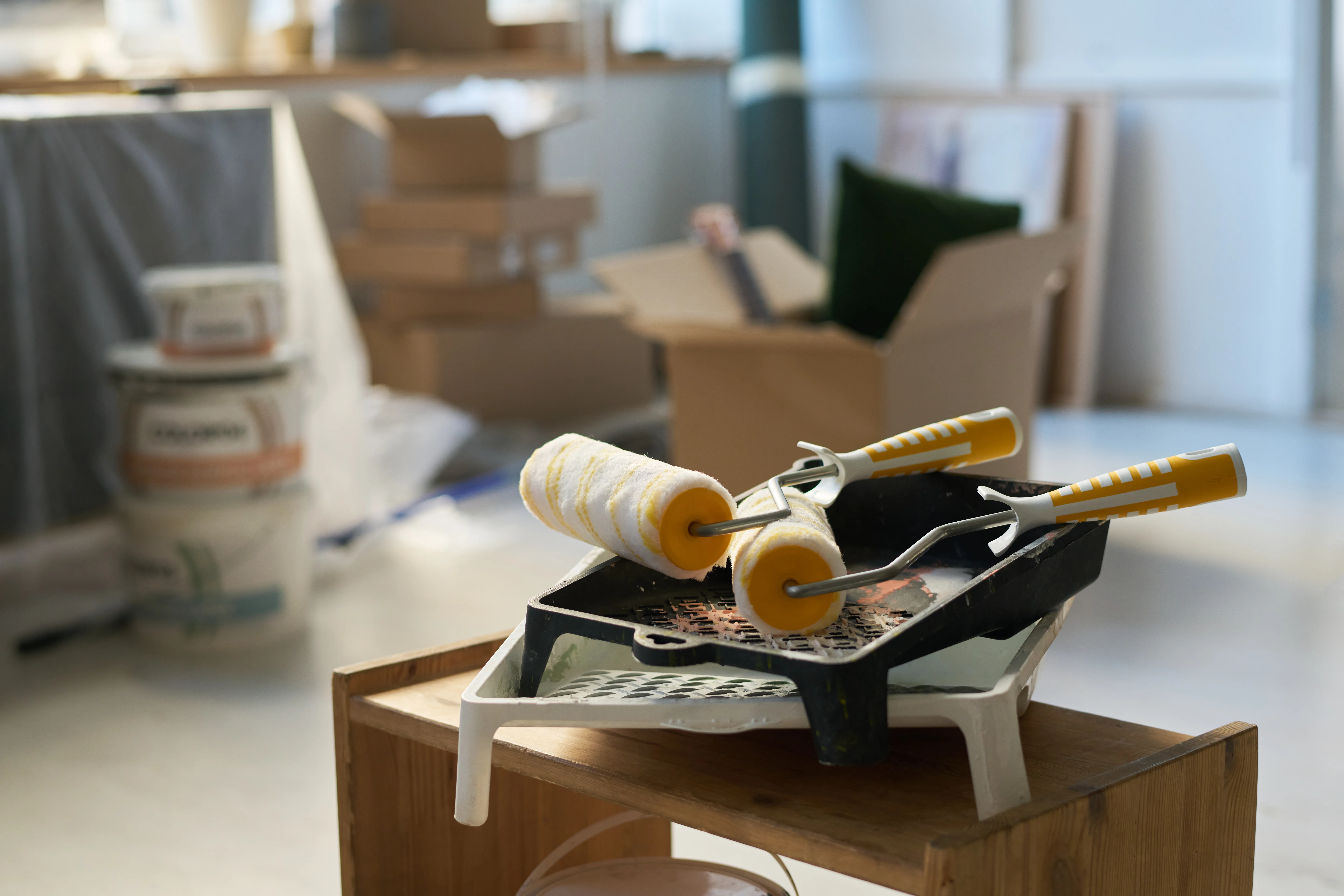Paint rollers and tray ready for interior painting service in a well-lit room