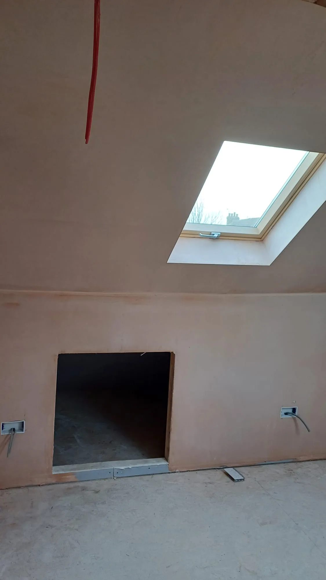 Interior wall with sloped ceiling and skylight, prepared for painting service