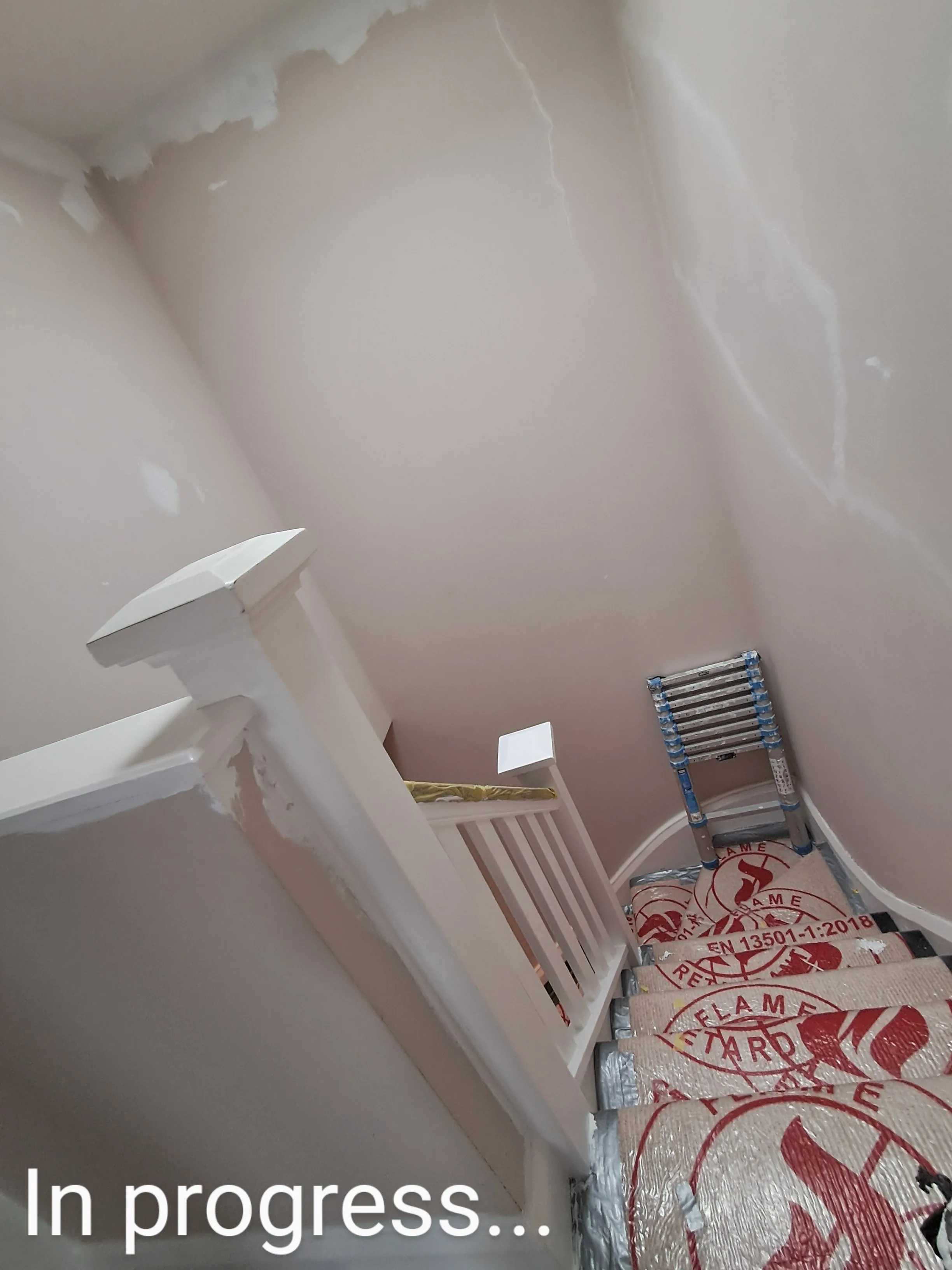 Ongoing interior painting project with partially painted stairs and walls
