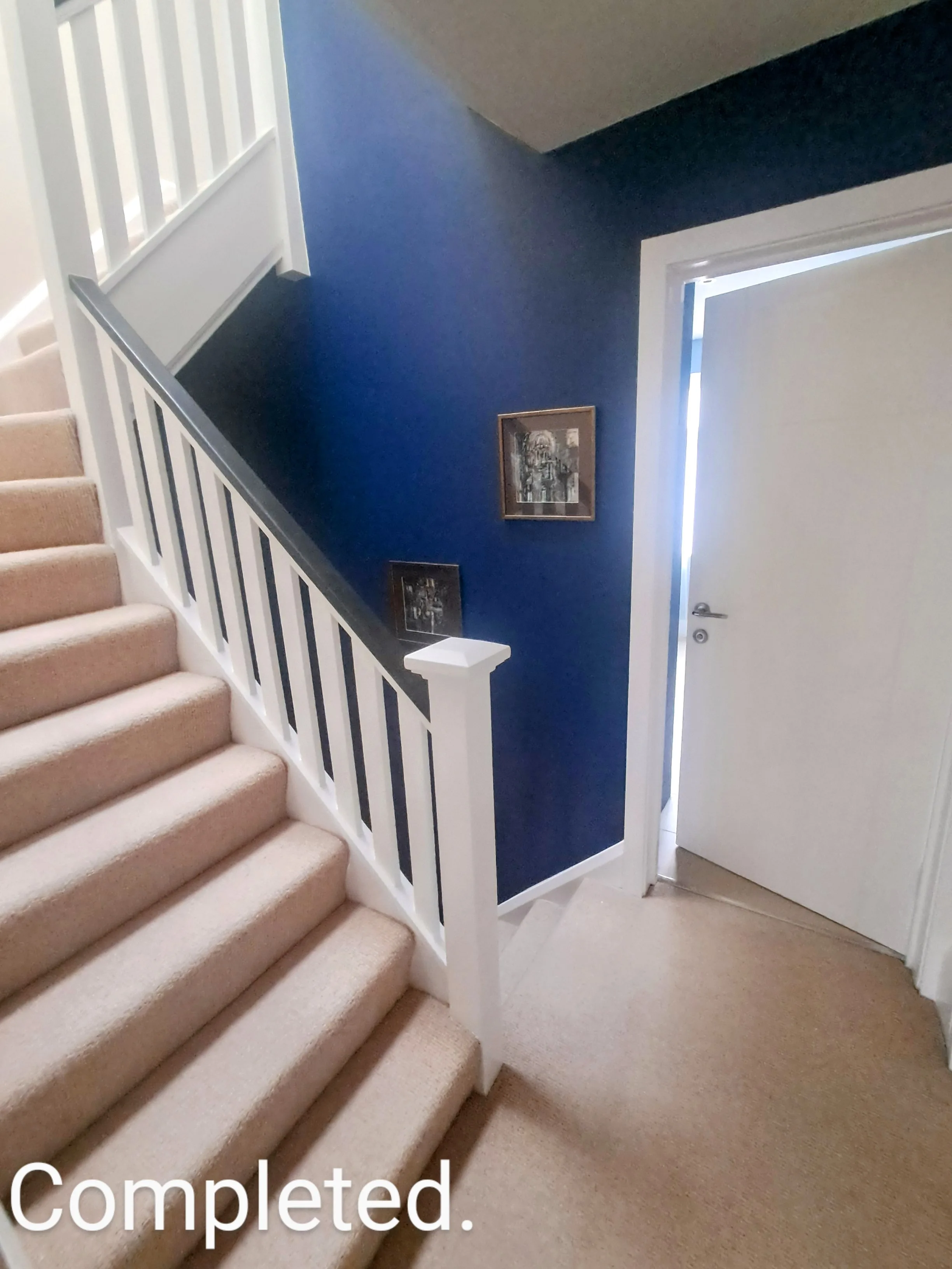 Interior view of a staircase with a blue wall and white trim, showcasing professional painting services
