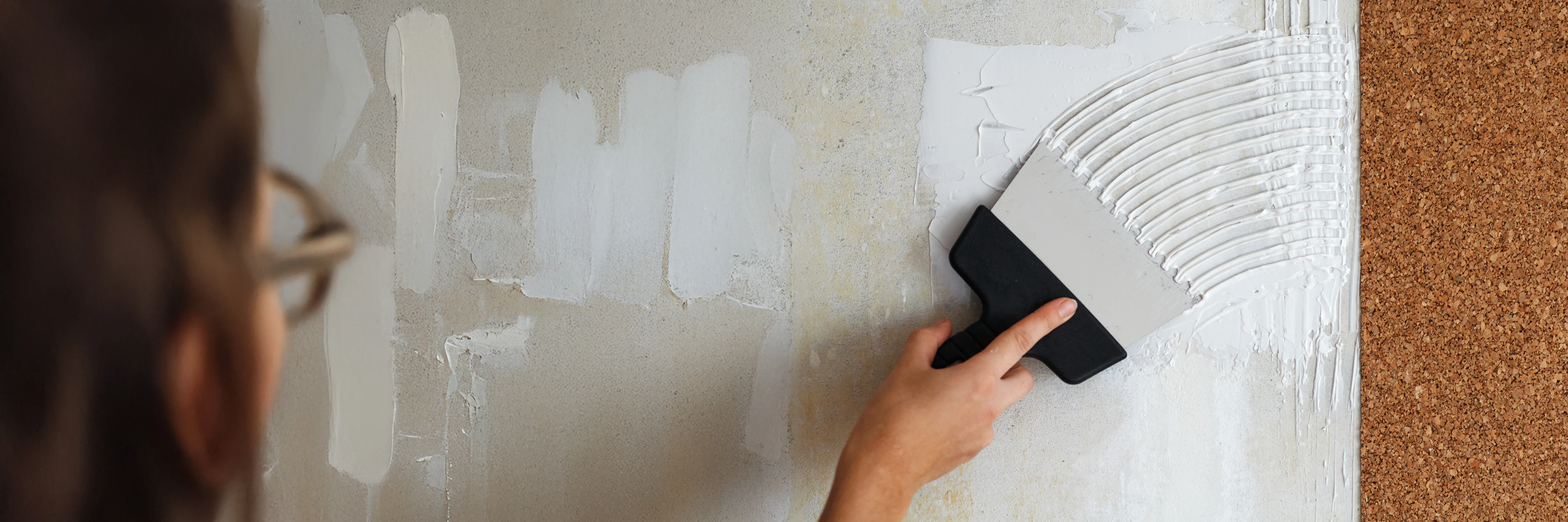 Applying wall repair compound with a trowel on a textured wall surface