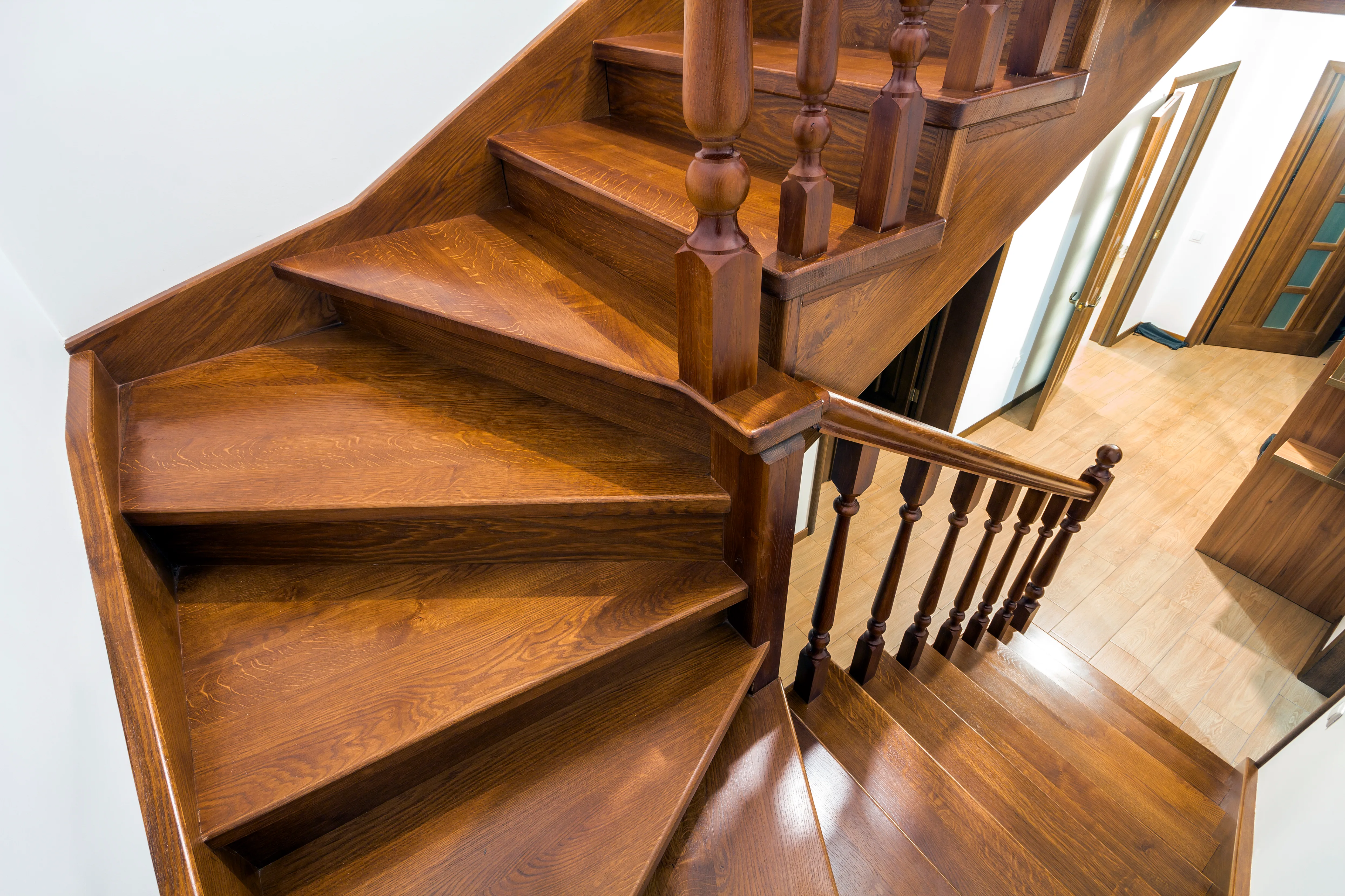 A wooden staircase with polished steps and banisters, showcasing high-quality craftsmanship in interior decorating
